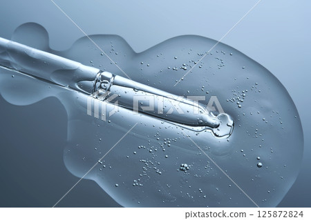 Anti-aging facial serum with a dropper on a blue background. 125872824