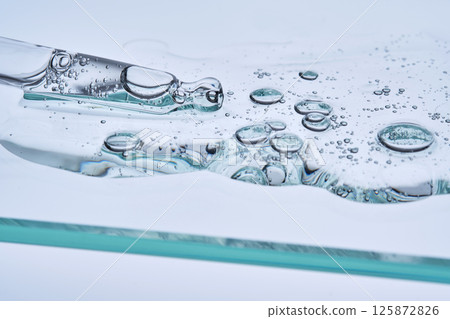 Serum with peptides on a blue background with a pipette. The texture. 125872826