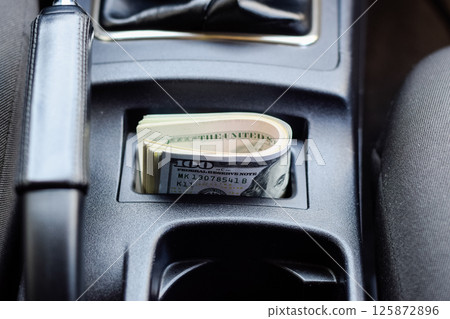 wad of dollars inside the car. wad of dollars inside the car. 125872896