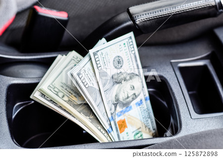 wad of dollars inside the car. wad of dollars inside the car. 125872898