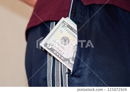 wad of money in the pocket of a man's pants. Dollars in your pocket. 125872926
