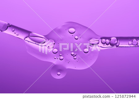 Two pipettes with serum on a lilac background. The texture. Two pipettes with serum on a lilac background. The texture. 125872944