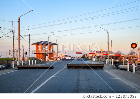 Railroad crossing with a barrier and a traffic light. Railroad crossing with a barrier and a traffic light. 125873052