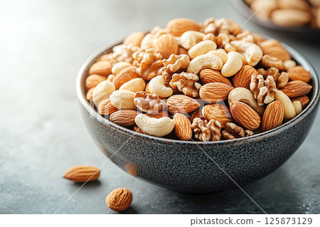 Healthy mix of almonds, walnuts and cashews in a bowl. Healthy mix of almonds, walnuts and cashews in a bowl. 125873129