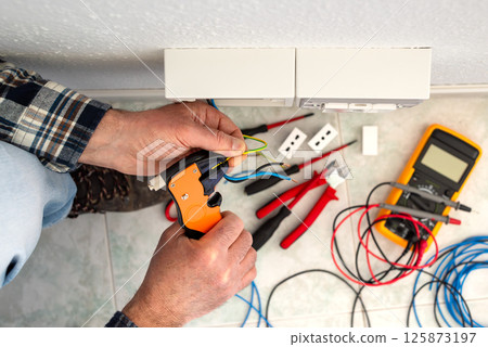 Electrician at work on a residential electrical system. Electricity. 125873197