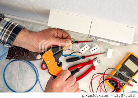 Electrician at work on a residential electrical system. Electricity. Electrician at work on a residential electrical system. Electricity. 125873198