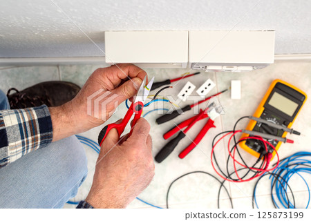 Electrician at work on a residential electrical system. Electricity. 125873199
