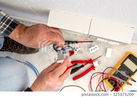 Electrician at work on a residential electrical system. Electricity. 125873200