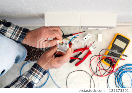 Electrician at work on a residential electrical system. Electricity. 125873201