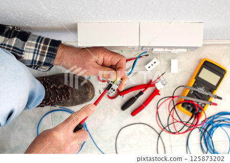 Electrician at work on a residential electrical system. Electricity. 125873202