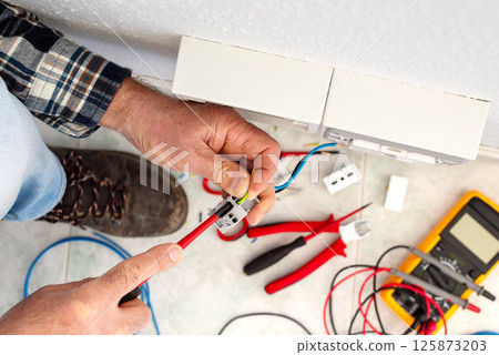 Electrician at work on a residential electrical system. Electricity. 125873203
