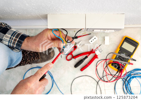 Electrician at work on a residential electrical system. Electricity. 125873204