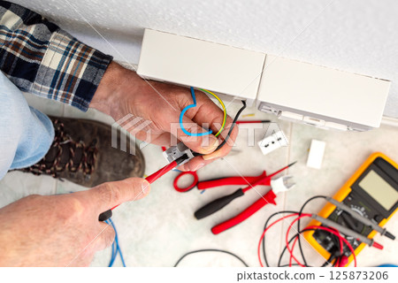 Electrician at work on a residential electrical system. Electricity. 125873206