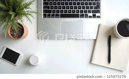 Flat lay top view of modern office desk, laptop, coffee, notebook, pen, minimalist aesthetic, natural lighting 125873276