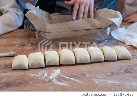 Woman preparing traditional cinnamon rolls in kitchen Woman preparing traditional cinnamon rolls in kitchen 125873452