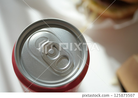 Soda can with open tab beside delicious burger meal at lunchtime 125873507
