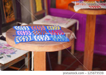 Colorful woven textile displayed on wooden table in craft market Colorful woven textile displayed on wooden table in craft market 125873539