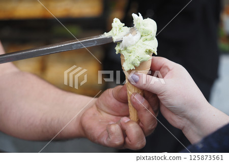 Ice cream being served at a local shop on a sunny afternoon 125873561