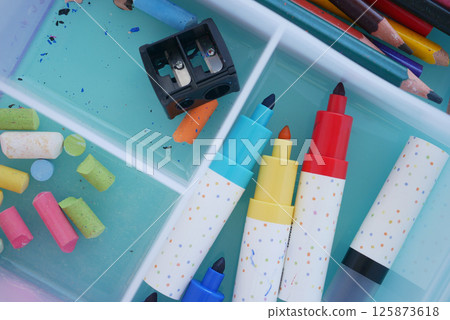 Colorful art supplies organized in a craft box on a bright surface Colorful art supplies organized in a craft box on a bright surface 125873618