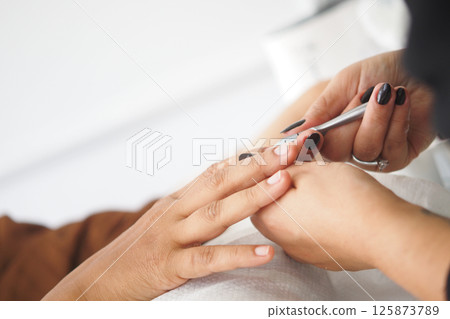 Nail technician performing manicure with stylish nail art 125873789