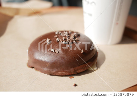 Delicious chocolate-coated dessert on a wooden table Delicious chocolate-coated dessert on a wooden table 125873879