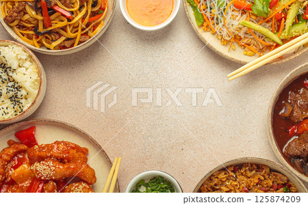 Variety of Chinese food dishes top view on table with chopsticks forming a frame with space for text, light beige background, cuisine of China Variety of Chinese food dishes top view on table with chopsticks forming a frame with space for text, light beige background, cuisine of China 125874209