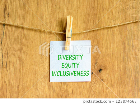 DEI diversity equity inclusiveness symbol. Concept words Diversity Equity Inclusiveness on white paper. Beautiful wooden background. Business DEI diversity equity inclusiveness concept. Copy space. 125874565