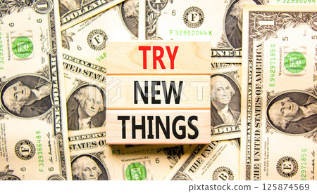 Try new things symbol. Concept words Try new things on beautiful wooden blocks. Dollar bills. Beautiful background from dollar bills. Business motivational lifestyle try new things concept. Copy space 125874569