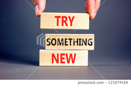 Try something new symbol. Concept words Try something new on beautiful block. Businessman's hand. Beautiful grey background. Business motivational lifestyle try something new concept. Copy space. 125874589