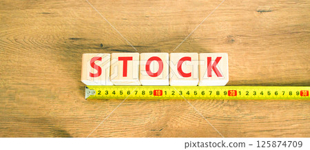 Stock symbol. Concept word Stock on beautiful wooden blocks. Beautiful wooden table wooden background. Beautiful yellow ruler. Business lifestyle stock concept. Copy space. 125874709