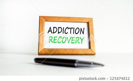 Addiction recovery symbol. Concept words Addiction recovery on beautiful wooden picture frame. Black pen. Beautiful white background. Psychology addiction recovery concept. Copy space. 125874812