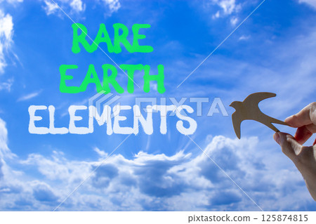 Rare earth elements symbol. Concept words Rare earth elements. Beautiful blue sky clouds background. Businessman hand, wooden birds. Business and rare earth elements concept. Copy space. 125874815