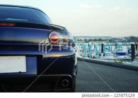 A famous rotary engine car standing in a port town 125875129