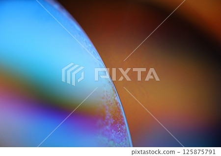 Bright rainbow reflection of liquid, blue and green colours, surrealistic pattern 125875791