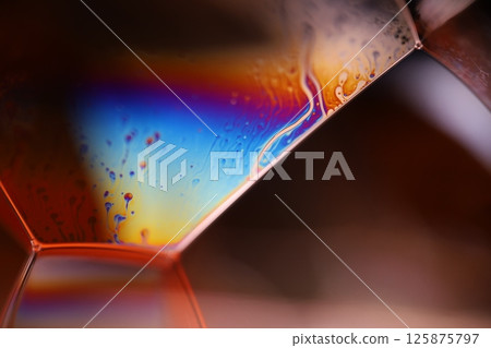 Bright rainbow reflection of liquid on black background, red colours, surrealistic pattern 125875797