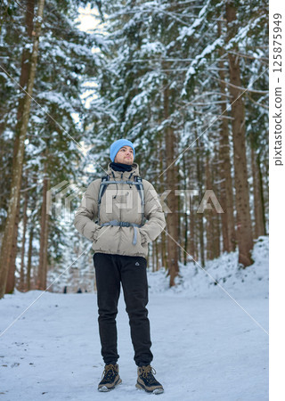 Winter Wonderland Adventure Young Man Hiking Snow Covered Forest Path Surrounded by Towering Pine Trees Serene Nature Exploration Scene Capturing Outdoor Enthusiast in Cozy Cold Weather Gear Winter Wonderland Adventure Young Man Hiking Snow Covered Forest Path Surrounded by Towering Pine Trees Serene Nature Exploration Scene Capturing Outdoor Enthusiast in Cozy Cold Weather Gear 125875949