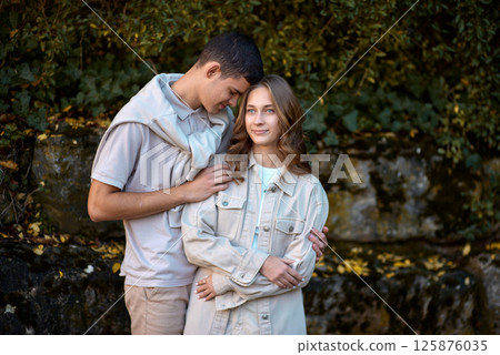 Embracing Teen Love in the Greenery of the Park. 125876035