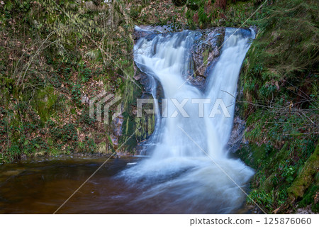 Majestic Allerheiligen Waterfalls: Serene Long Exposure Cascade in Black Forest National Park Germany. Scenic Forest Stream Flows Through Lush Greenery and Moss Covered Rocks Creating Ethereal Majestic Allerheiligen Waterfalls: Serene Long Exposure Cascade in Black Forest National Park Germany. Scenic Forest Stream Flows Through Lush Greenery and Moss Covered Rocks Creating Ethereal 125876060