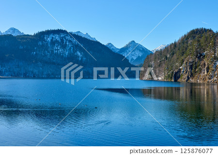 Serene Frozen Mountain Lake Reflects Majestic Alpine Peaks Under Clear Blue Sky Pristine Winter Wonderland Captures Nature's Icy Beauty Serene Frozen Mountain Lake Reflects Majestic Alpine Peaks Under Clear Blue Sky Pristine Winter Wonderland Captures Nature's Icy Beauty 125876077