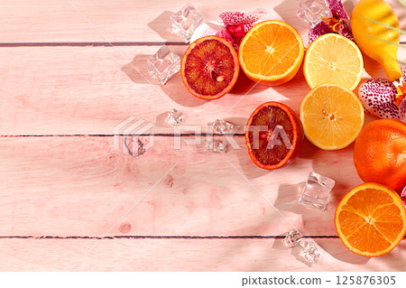 Modern still life with exotic citrus fruits on sunny table with shadows from palm tree,summer holiday concept.Summer banner with tropical fruits,healthy vegan food for weight loss Modern still life with exotic citrus fruits on sunny table with shadows from palm tree,summer holiday concept.Summer banner with tropical fruits,healthy vegan food for weight loss 125876305