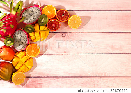 Summer banner with tropical exotic fruits, Dragon fruit, pitaya, mango and oranges on a sunny table. Template for design. Healthy vegan food for weight loss, Advertising card for a store Summer banner with tropical exotic fruits, Dragon fruit, pitaya, mango and oranges on a sunny table. Template for design. Healthy vegan food for weight loss, Advertising card for a store 125876311