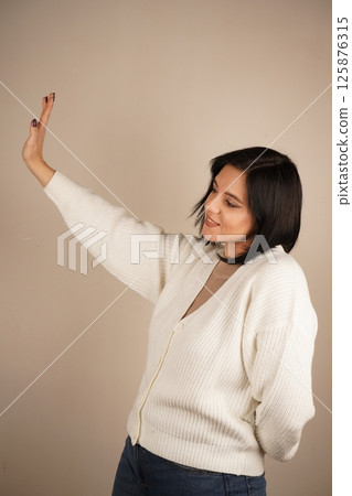 A universal expression of halting action or setting boundaries. A single hand raised with an open palm delivers a clear "stop" signal. The firm gesture conveys authority and the need to pause. 125876315
