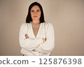 Businesswoman isolated, businesswoman standing with arms crossed and smiling, front view. 125876398