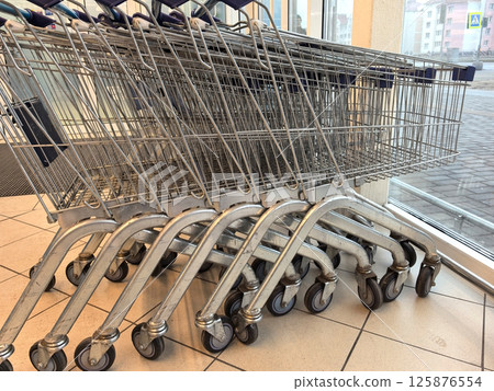 Shopping carts lined up near an entrance on a bright afternoon 125876554