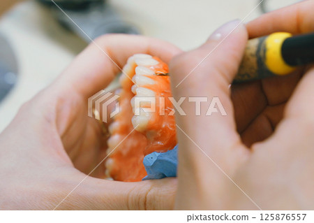 Crafting detailed dentures with precision in a dental workshop setting 125876557