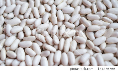 Close-up image of a large pile of white kidney beans, also known as cannellini beans.  125876766