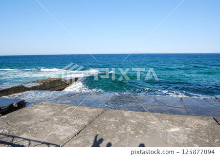 Odessa Bay of the Black Sea.  On a cloudy day, the Black Sea rolls in small waves onto the sandy beaches of Odessa. 125877094