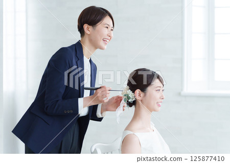 Hair and makeup at the wedding venue and the bride Hair and makeup at the wedding venue and the bride 125877410