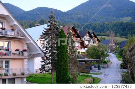 Charming mountain village in Slovenia with traditional alpine-style houses featuring wooden balconies and flower boxes Charming mountain village in Slovenia with traditional alpine-style houses featuring wooden balconies and flower boxes 125877483