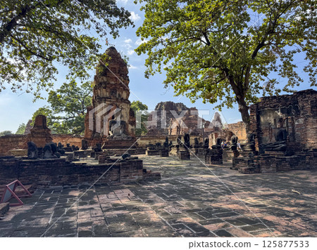 Spiritual Buddha statues outdoors at the old Thai temple landmark, Wat Maha That tourism. Ancient historical brick structures symbolizing peace and spirituality, famous Buddhist culture. Spiritual Buddha statues outdoors at the old Thai temple landmark, Wat Maha That tourism. Ancient historical brick structures symbolizing peace and spirituality, famous Buddhist culture. 125877533